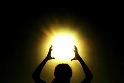 A person holding their hands up to the sun.